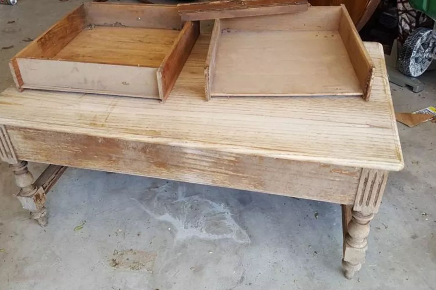 An antique wooden table featuring two drawers on the top surface, showcasing its vintage design and craftsmanship.