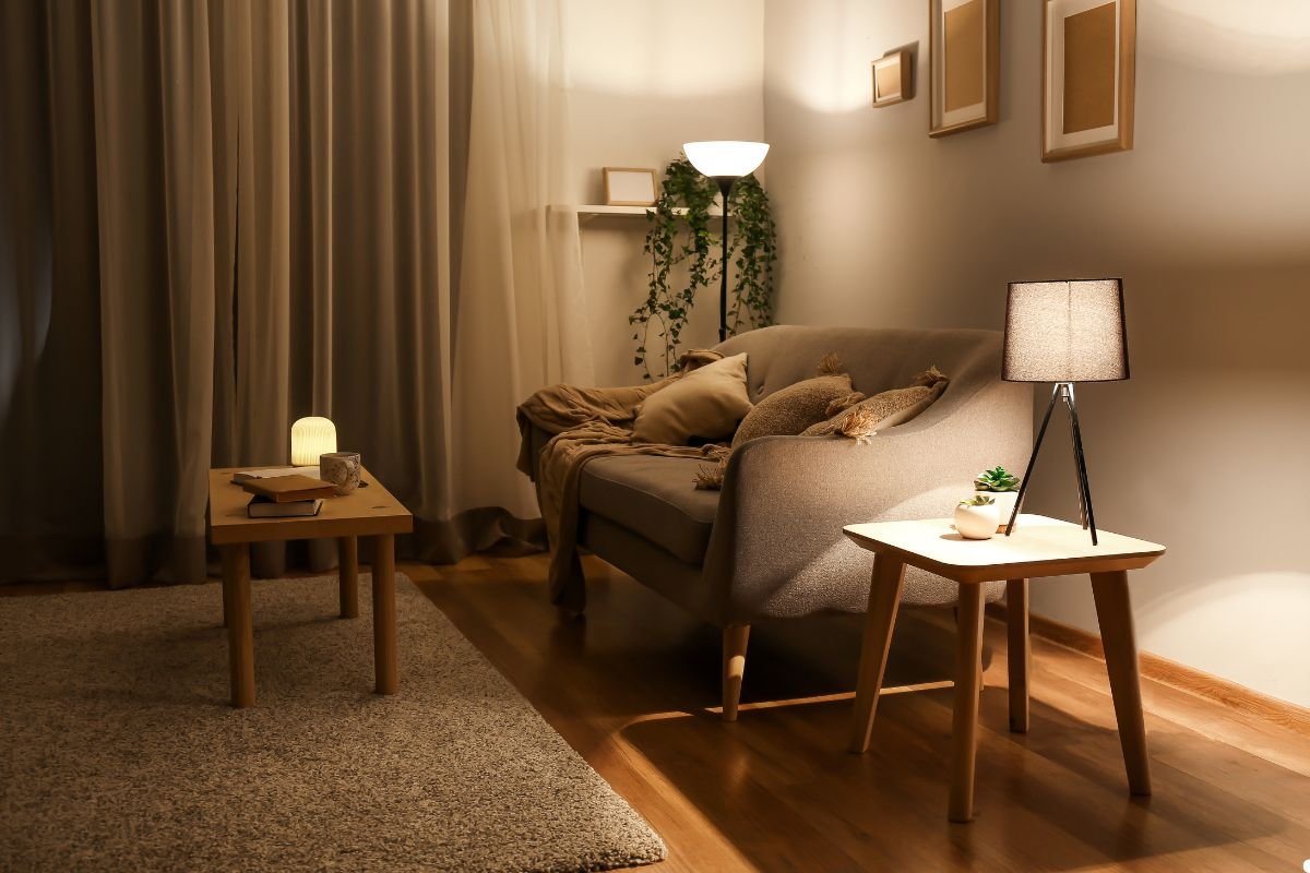 A cozy living room featuring a couch, a coffee table, and a standing lamp, creating a warm and inviting atmosphere.