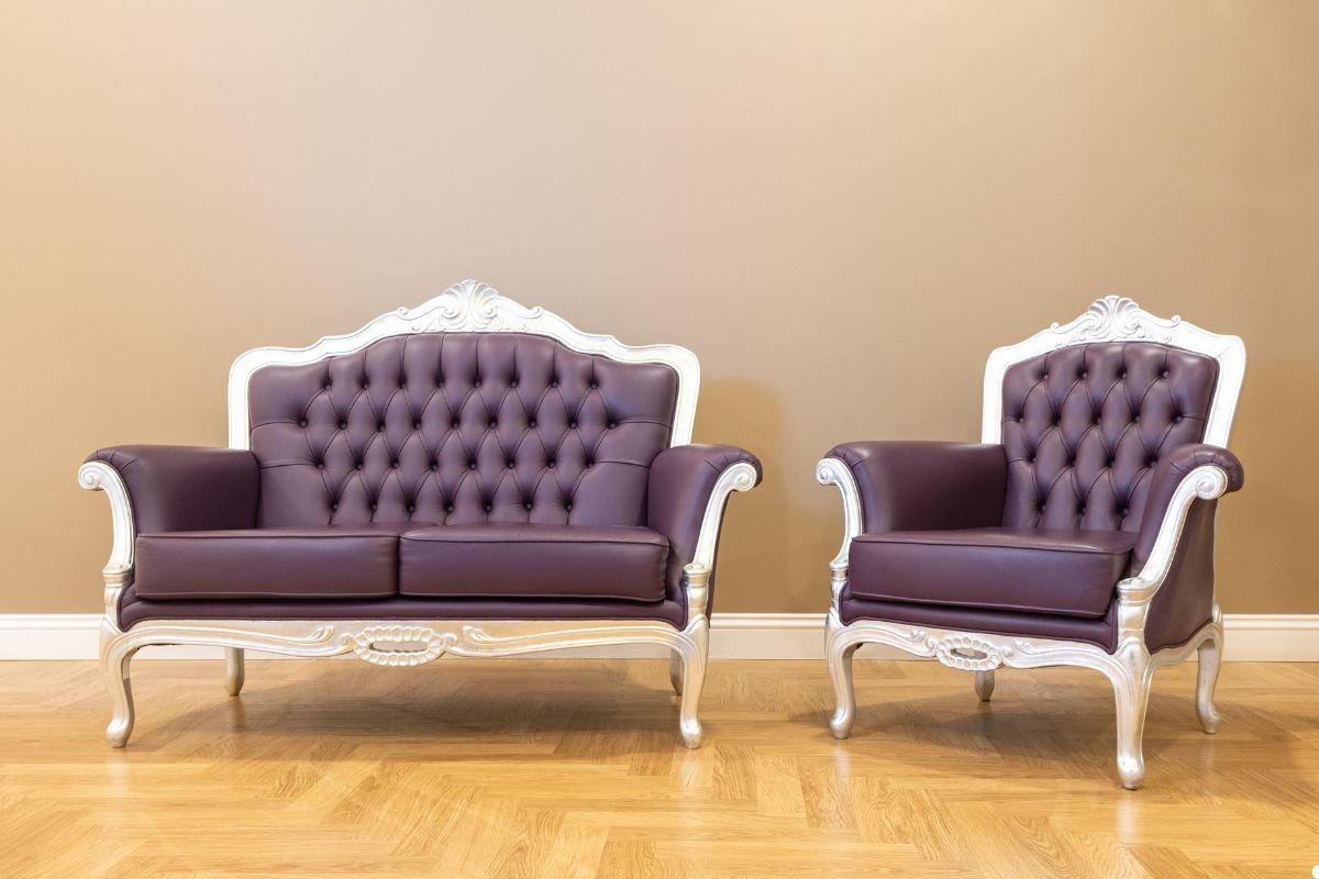 Two purple leather sofas positioned on a polished wooden floor, creating a stylish and modern living space.